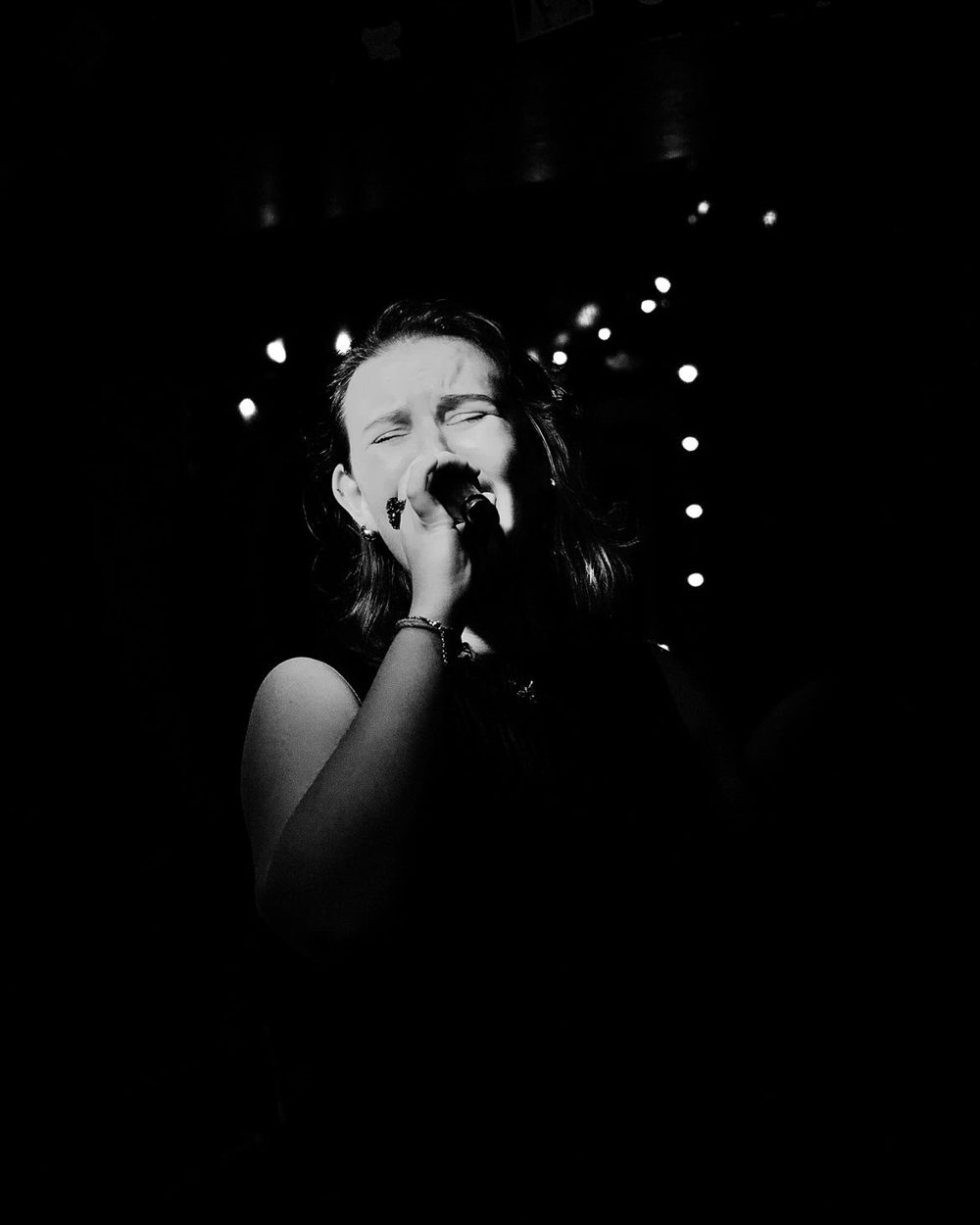 Black and white close-up of Fifi singing into the microphone at her Jacaranda headline show